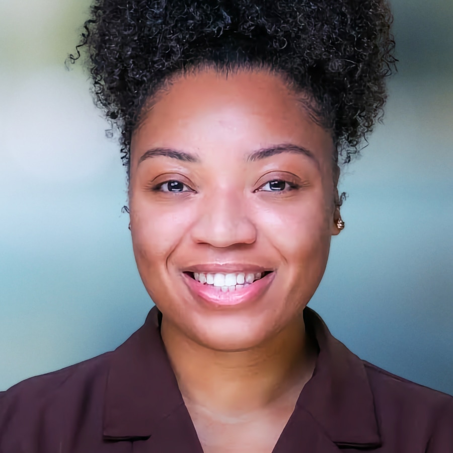 Therapist Mikayla Singleton; a smiling young woman with curly hair stacked on top of her head