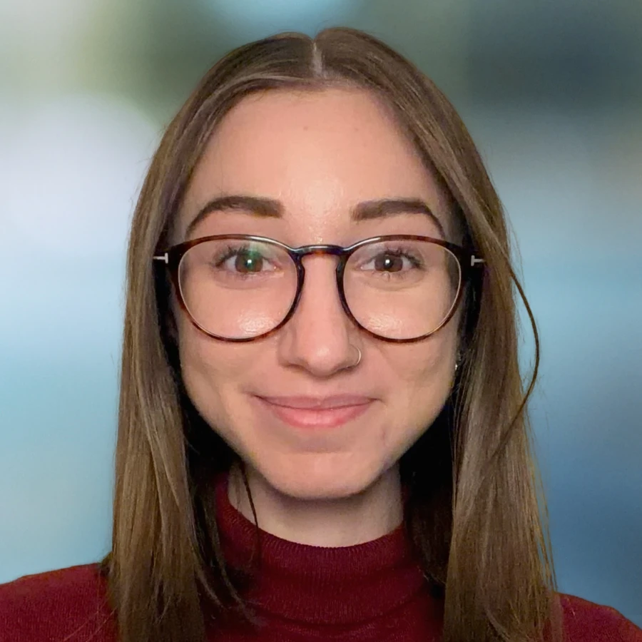 Headshot of Larisa Esposito, an online mental health therapist, wearing glasses and a red top, smiling confidently at the camera.